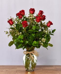 Long stem roses are a classic expression of love and sweet affection! Red roses arrive accented with lush greens, all beautifully arranged in a clear glass vase