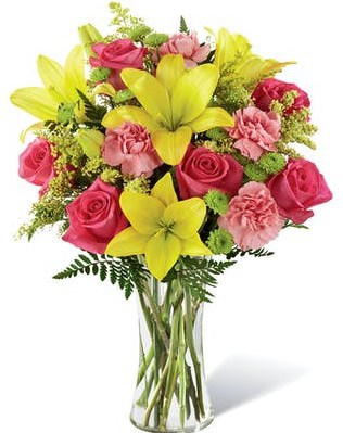 Light, lovely, and set to surprise and delight your recipient with it's bright blooms, this flower bouquet speaks to the magic that each day holds. Brilliant yellow Asiatic Lilies are surrounded by hot pink roses, pink carnations, yellow solidago, and lush greens, beautifully arranged in a classic clear glass vase to create a gift that exudes warmth and happiness.