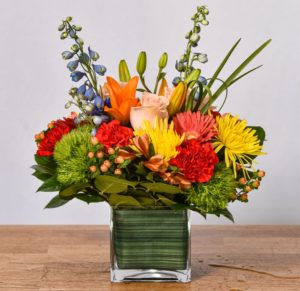 This colorful array of flowers arranged in a clear glass vase is perfect to give for a any occasion.