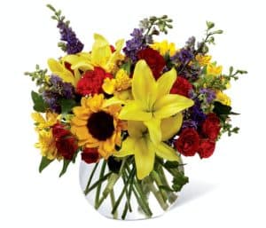 Your recipient always takes care of everyone else - they are thoughtful, they are kind, and they are completely deserving of a special surprise consisting of bright, beautiful blooms. Sunlit yellow Asiatic Lilies, sunflowers, red carnations, red spray roses, yellow Peruvian Lilies, purple larkspur, and ivy vines are expertly arranged in a clear glass bubble bowl vase to express your appreciation in floral style. A wonderful birthday, thank you, or thinking of you gift! GOOD bouquet includes 13 stems. Approx. 11"H x 10"W. BETTER bouquet includes 17 stems. Approx. 12"H x 11"W. BEST bouquet includes 21 stems. Approx. 15"H x 14"W. EXQUISITE bouquet includes 24 stems. Approx. 16"H x 15"W.